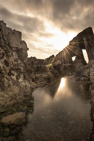 Обои небо, скала, свет, арка, облака, скалы, камни, берег, лучи, море, the sky, rock, light, arch, clouds, rocks, stones, shore, rays, sea разрешение 3840x2160 Загрузить